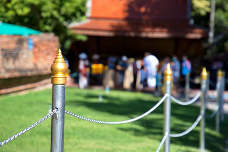 Pillar with golden Thai style crest and silver chain For separating the archaeological site of a temple in Thailandの写真素材