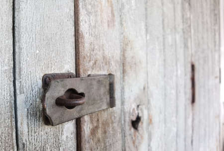 Old rusted hinge on the old wooden door There is an area to the right for text input. Selective focus.の写真素材