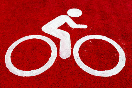 A view of a cyclist who sees a white sprayed symbolizing the cycling path on a red tire surface.の写真素材