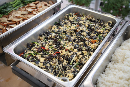 Sauteed Ear Mushroom with Egg in buffet line. The container is a rectangular stainless steel tray. Selective focus.の写真素材