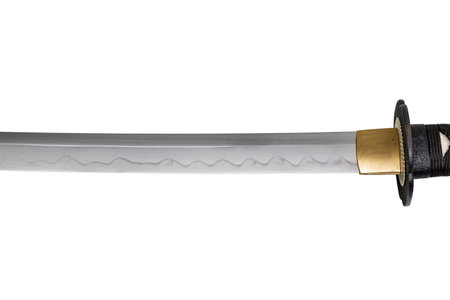 The Habaki - collar is made of polished brass. It is at the base of a Japanese sword blade with a wavy pattern on the sharp part. isolated on a white background. Selective focus.の写真素材