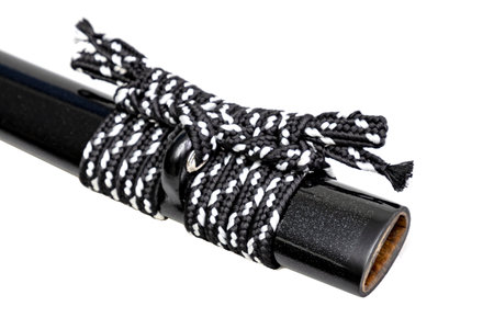 Close up shot of Sageo - Thick black-white silk rope for tying the scabbard of Japanese swords. It was a rope for the samurai to tie at the waist. isolated on white background. Selective focus.の写真素材