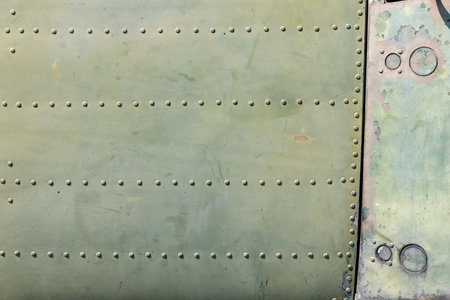 The exterior wall surface of a very old military green military helicopter. in the bright sunlight during the dayの写真素材