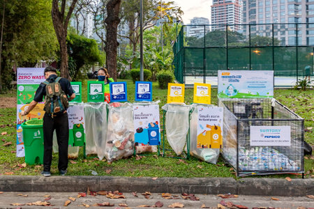 Bangkok, Thailand - Dec 8, 2022: A man throws rubbish by categories organized by government agencies at the Red Cross Fair at Lumpini Park from Dec 8-18, 2022. The image is blurred because of movementのeditorial素材