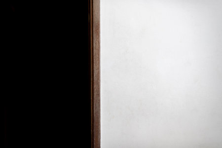 A white painted cement wall with a bit of dirt on the outside of the building during the daytime....