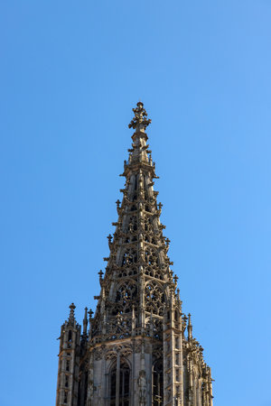HDR image of Ulm Minster, the tallest church in the world, showcasing Gothic details under a clear blue sky on a sunny day. Perfect for travel, architecture, historical and inspiring design projects.の写真素材