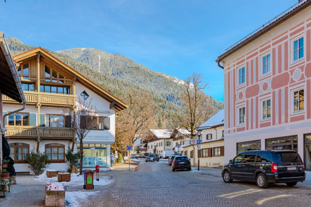 Partenkirchen, Garmisch-Partenkirchen, Bavaria, Germany â November 28, 2025: A quiet winter street in the village of Partenkirchen, with traditional Bavarian buildings and snow-dusted mountain slopes in the background.のeditorial素材