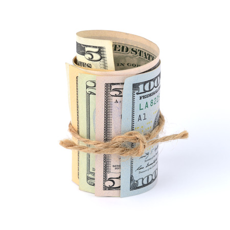 Dollar bills rolled up and tied with a rope. Isolated on white background