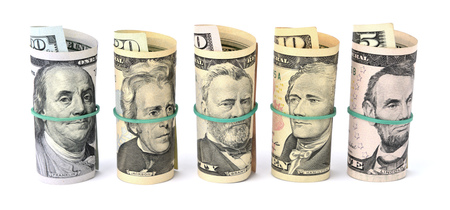 Dollar bills rolled up and tied with a rope. Isolated on white backgroundの写真素材