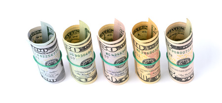 Dollar bills rolled up and tied with a rope. Isolated on white backgroundの写真素材