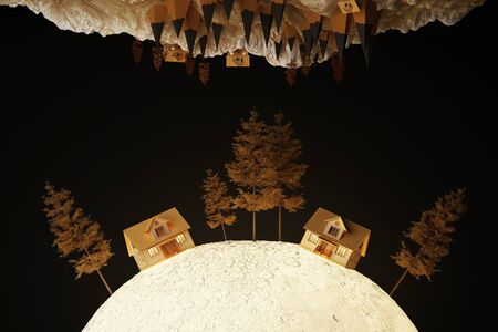 A cute yellow house on the moon glowing light surrounded by trees.の写真素材