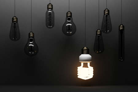 Glowing light fluorescent bulb LED isolated on black concrete background surrounded by incandescent lamp - 3D Renderingの写真素材