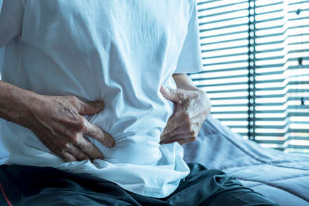 Asian Elderly man Stomachache in bedroom.の写真素材