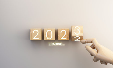 New year 2023 Loading. Countdown from 2022 to 2023 with wooden cartoon hand putting wood cube in...
