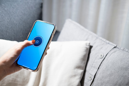 Smart home concept Controlling lights, lamps, or home appliances through a mobile application. A...