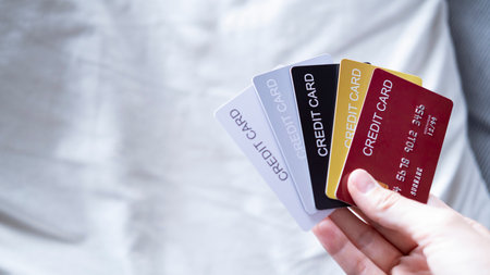 Hand is hold five credit cards. Black gold silver and red color credit cards. isolated on white sofa...