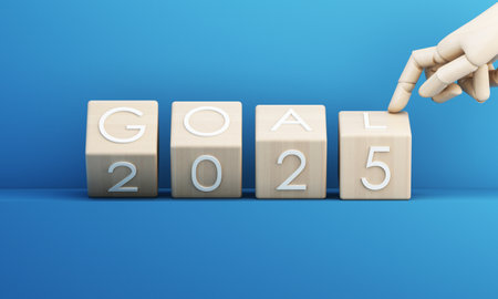 Wooden cubes spell out GOAL 2025 on a blue background, with a robotic hand pointing to the final...