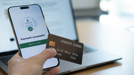 A successful payment confirmation on smartphone while holding a credit card, symbolizing the fast and secure nature of digital financial transactionsの写真素材