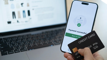 Smartphone showing payment successful next to credit card and laptop, reflecting a complete and seamless digital shopping experienceの写真素材