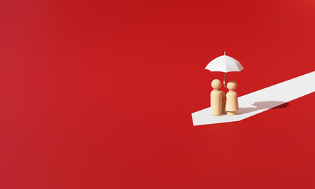 Wooden human family figures under an umbrella on a white path over red background, representing family care and life insurance protection. 3d rendering.の写真素材