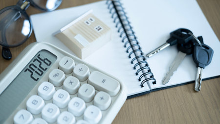 House model, calculator and keys on notebook, symbolizing home ownership, mortgage loan, insurance...