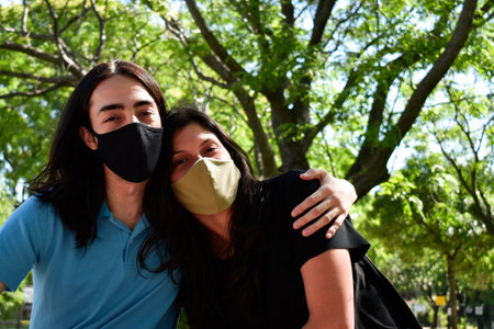Portrait of engaged couple at the park, A man and a woman hug each otherの写真素材