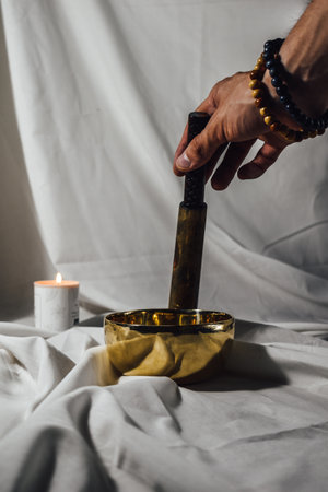 A man plays the National musical instrument Tibetan singing bowl close-up