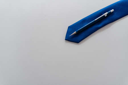 over head view of a blue tie with a mechanical pencil, pen on top. with large copy spaceの写真素材