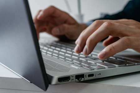 computer connectivity inputs while a businessman type on a modern all gray computer