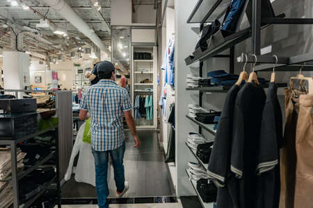 man standing on his back in a shopping mall buying clothes, with a shopping bag in his hands. Buenos Aires. Falabellaの写真素材