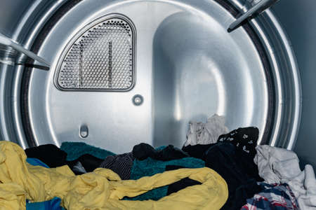 clothes of many colors drying in the dryer, already washed in the washing machine. industrial dryer. domestic dryer. fast drying. view from inside the washing machine.の写真素材