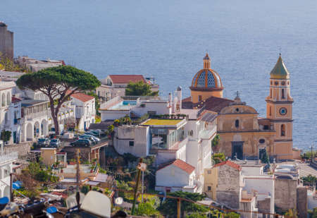 Green trees, sandy beach and colorful Amalfi houses on hills leading down to coast, Campania, Italy. Amalfi coast is most popular travel and holiday destination in Europe.の写真素材