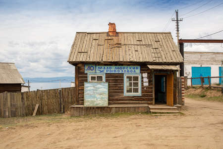 Retro vintage small wooden house. The inscription on the building is in Russian MALO-MORSKIY FISH FACTORY. Khuzhir is the main village on Olkhon Island in Lake Baikal in eastern Siberia. The photo was taken in the summer in July.のeditorial素材