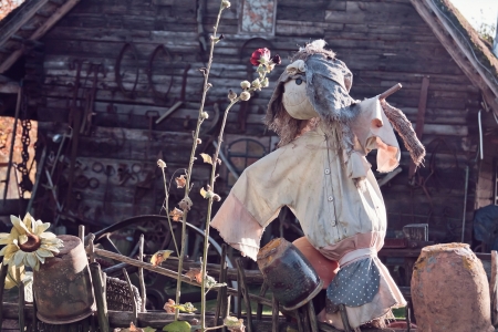 scarecrow with old wooden house in a backgroundの写真素材
