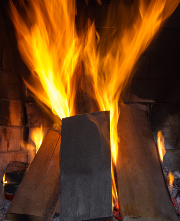 Burning firewood in the fireplace close upの写真素材