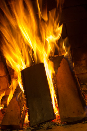 Burning firewood in the fireplace close upの写真素材