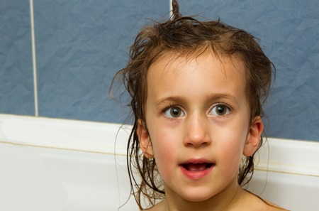 Cute little girl washes her hair. Clean kid after shower. Children hygiene. Child taking bath....
