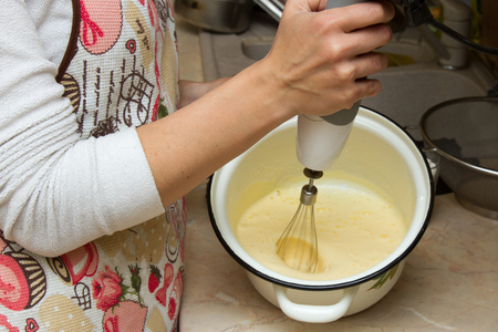 Young beautiful woman cooking baking dough with mixer at the kitchen, healthy food, cooking at home, hipster styleの写真素材