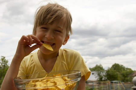 Girl eats chipsの写真素材