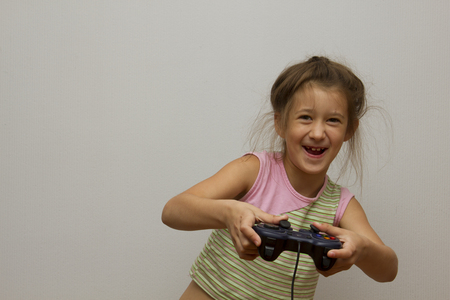 little girl playing with playstation joystickの写真素材