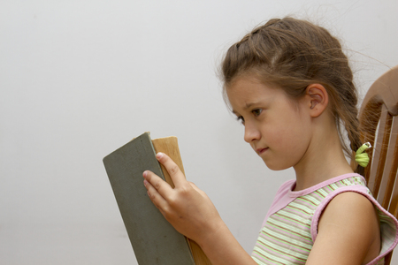 Girl is reading big bookの写真素材
