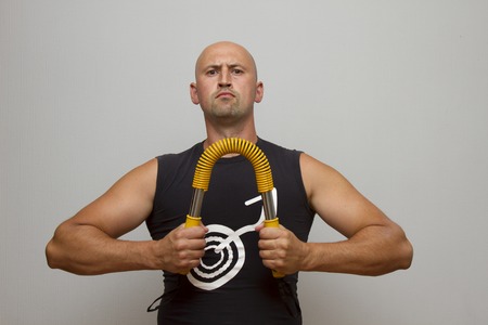 Young handsome man working out in the gym with gymnastic stick