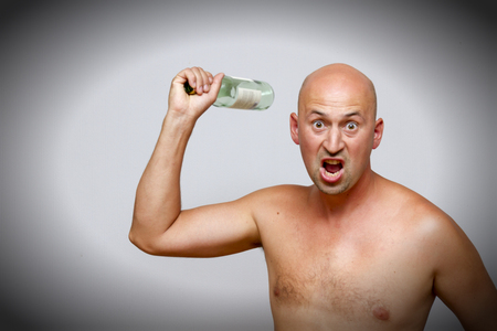 A drunk man blows a bottleの写真素材
