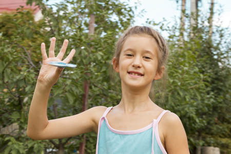 School aged girl playing with a gold fidget spinner. A popular trendy toy for the development of fine motor skills in children and adults close-up.の写真素材