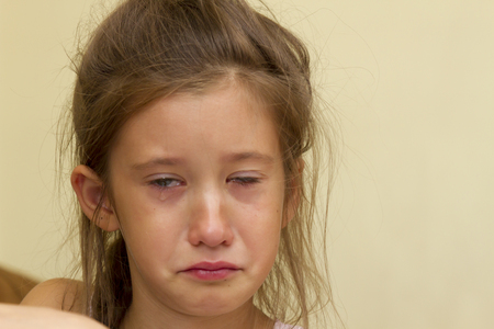 Portrait of little girl crying with tears rolling down her cheeksの写真素材