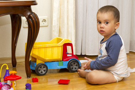 kid boy toddler playing with toy car indoorsの写真素材