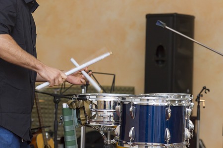 man plays musical percussion instrument with sticks closeup on a black background, a musical concept...