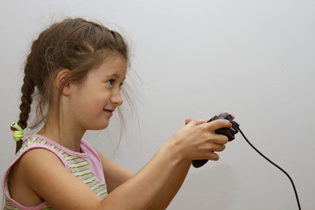 Little girl playing video games with gamepad in the hands.の写真素材
