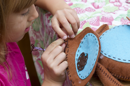 creation. little girl sews toy made of feltの写真素材
