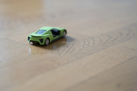 a toy car of green color on the floorの写真素材
